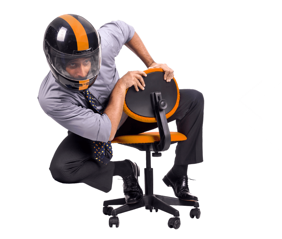 Uomo in camicia seduto su una sedia con casco che fa finta di guidare una moto